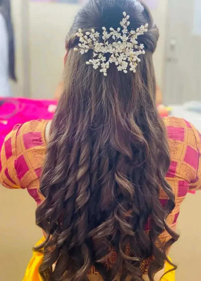 Bridal curls pinned with a pearl-flower hair vine, half-up, over an orange silk blouse