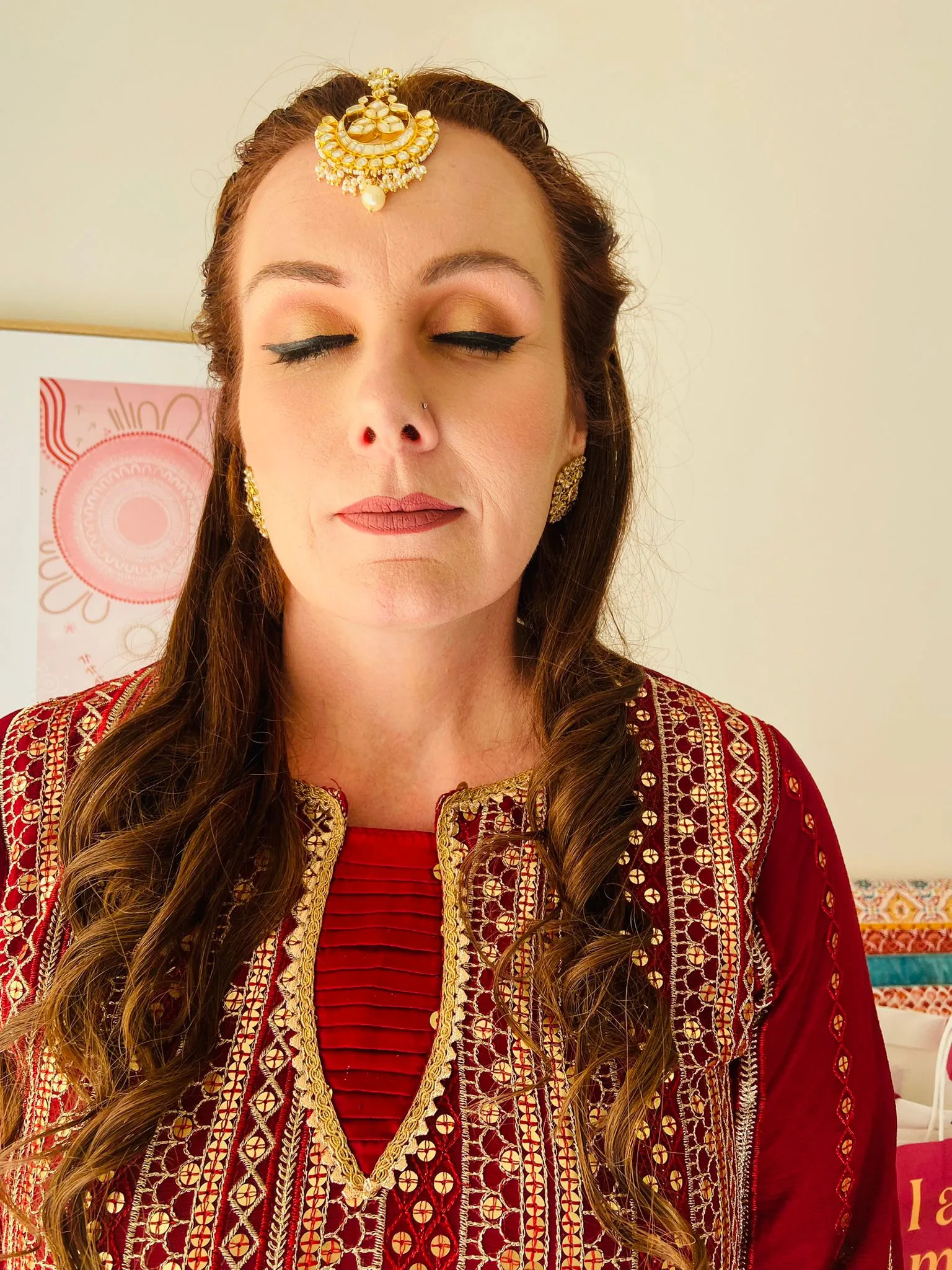 Warm bronze party makeup with maang tikka and gold earrings