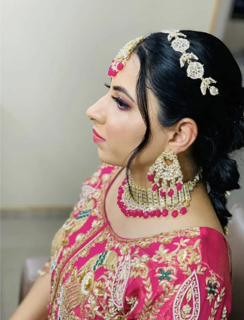 Bridal makeup profile — pink lehenga, gold jewellery, maang tikka and pink lip; salon work