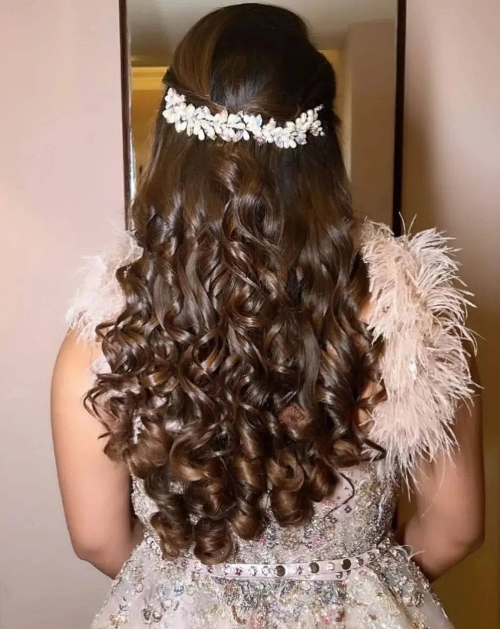 Bridal half-up of cascading curls crowned with a crystal and pearl hair vine, rear view